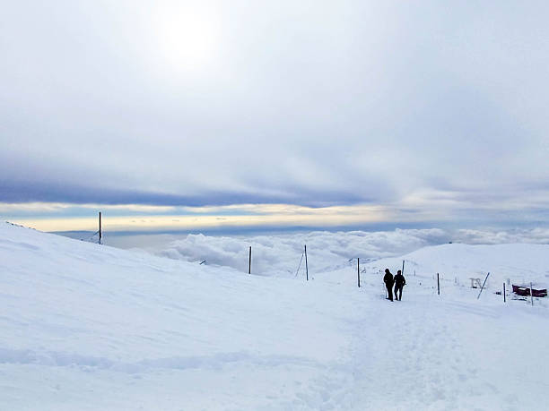 Fresh snowfall covers Tochal Peak in northern Tehran, Iran. Snowy mountain ridges and winter clouds create a dramatic alpine landscape overlooking the Iranian capital during the cold season.