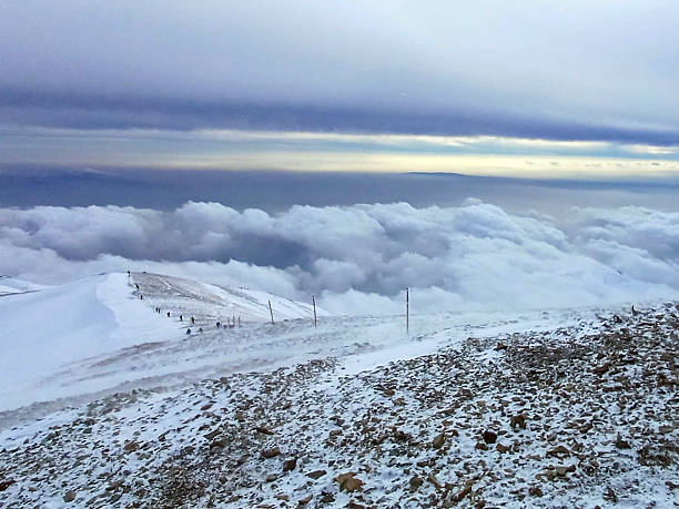 Fresh snowfall covers Tochal Peak in northern Tehran, Iran. Snowy mountain ridges and winter clouds create a dramatic alpine landscape overlooking the Iranian capital during the cold season.