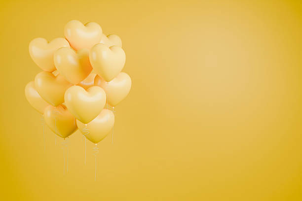 Yellow balloons shaped like hearts on yellow background