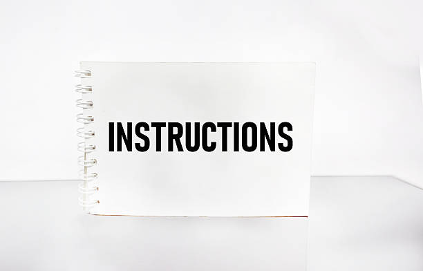 A person holds an open spiral notebook with lined pages against a green grass background. The notebook has spaces for No and Date at the top, making it ideal for journaling or note taking