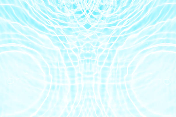 Bluewater waves on the surface ripples blurred. Defocus blurred transparent blue colored clear calm water surface texture with splash and bubbles. Water waves with shining pattern texture background.