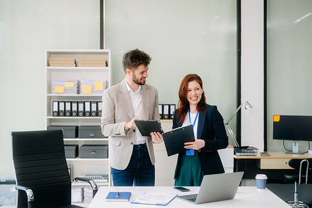 istock Two business workers talking on the smartphone and using laptop 2254862348