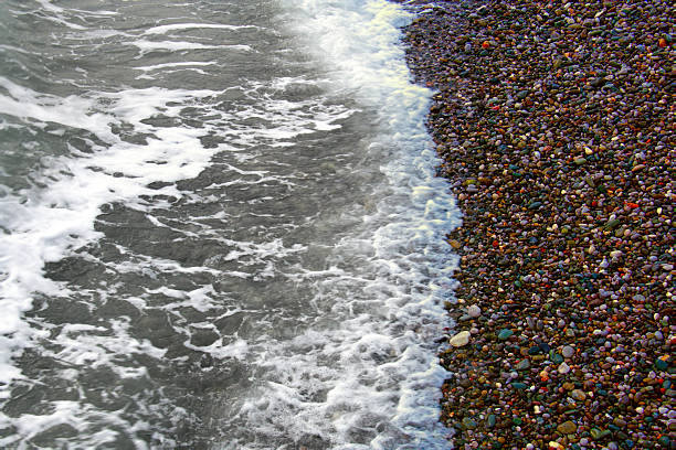 Sea rolling and receding water in rays of setting sun.