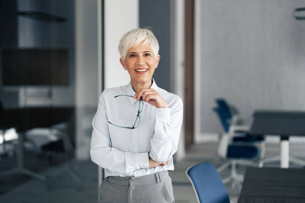 istock Senior businesswoman smiling confidentially while standing in office 2254869283