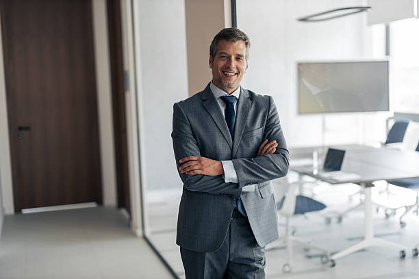 istock Confident businessman standing with arms crossed in modern office 2254869331