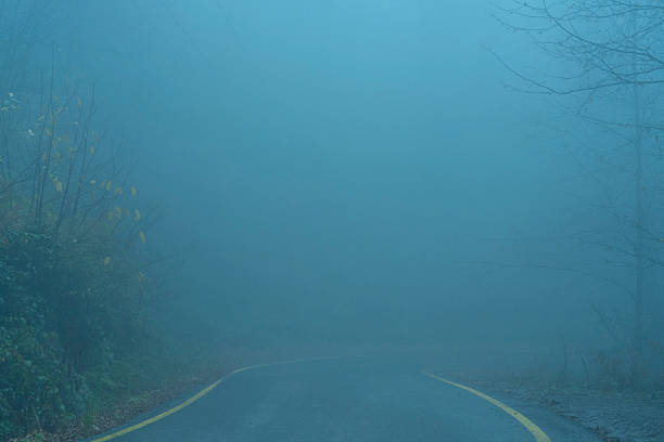 Bridge with worn asphalt over a river in the italian countryside on a foggy day