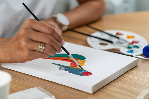 istock Woman focused on home painting project using basic craft supplies. Emphasizes technique practice and steady creative engagement. 2254873175