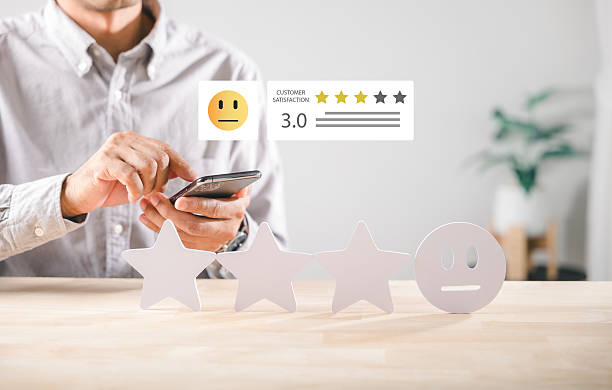 istock Customer satisfaction service rating shows user giving feedback with smartphone, evaluating three star experience on table, expressing neutral sentiment with survey concept, measuring overall review 2254875591