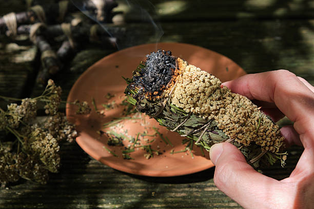 istock Woman’s hand holding herbal smudge stick with smoke in sunlight 2254877703