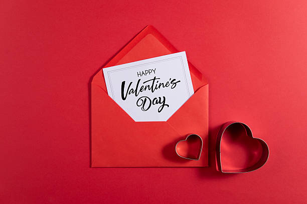 Red envelope and greeting card for Valentine’s Day on pink background
