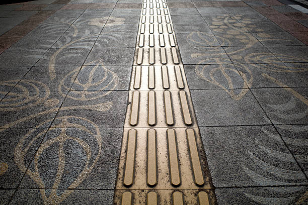 Yellow tactile paving for blind people or visually impaired on the sidewalk.