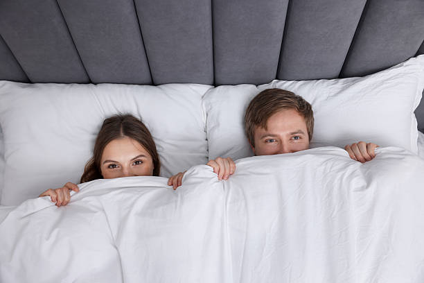 istock Lovely couple lying in bed at home, top view 2254885607
