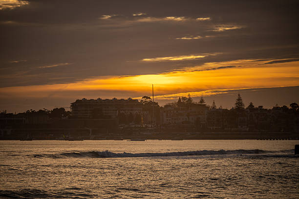 Estoril Portugal December 17 2025. Waterfront buildings line the coast beneath a glowing sunset sky over the Atlantic Ocean