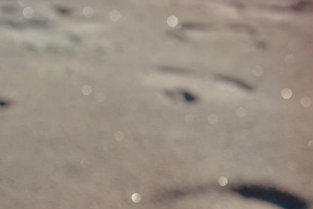 defocus light sun background with soft bokeh and lens flare over brown sand surface abstract nature composition for summer holiday design concept of warmth, serenity, travel.
