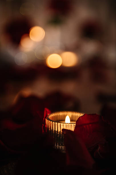 istock Luxury candlelight date. Candle and rose petals on the table. Romantic place setting on table in a restaurant. Detail decor. Romantic dinner setup at night. Valentine's Day evening for a couple. 2254900654