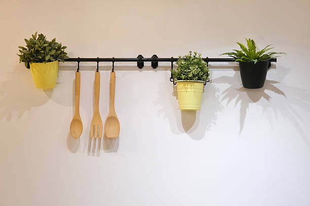 Stylish wall-mounted kitchen setup with plants and utensils adds charm and function to a modern interior.
