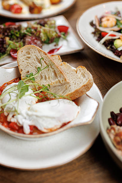 istock Delicious dishes from diverse cuisines featuring baked eggs, bread, and fresh vegetables served at a local restaurant during brunch 2254905967