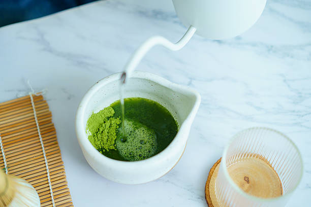 Pouring hot water into matcha green tea powder