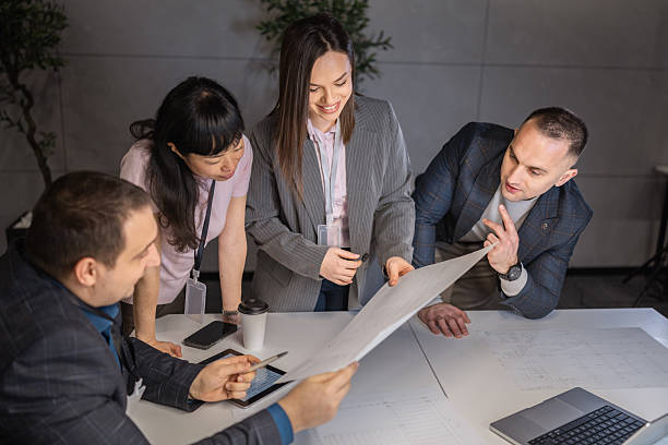 istock Group of diverse professionals collaborating over documents in modern office 2254914327