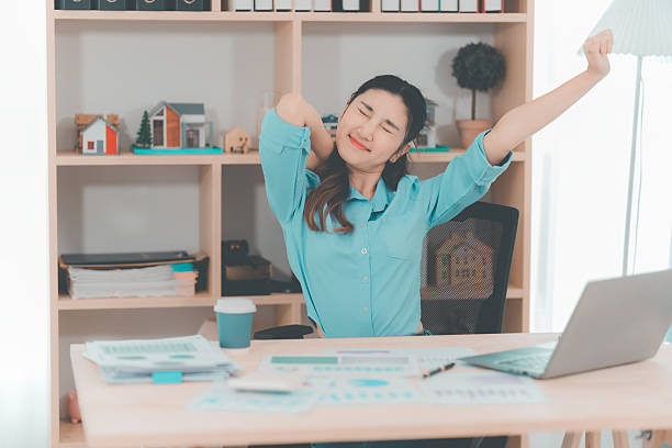 istock An Asian female accountant experienced severe, twisting pain while working at her desk, indicating possible poor posture or prolonged sitting. 2254917132