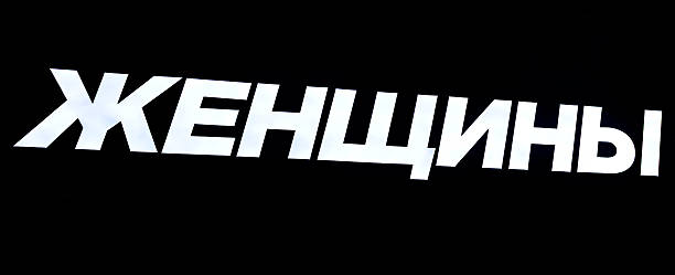 A glowing signboard on a black background. Text in Russian: Women