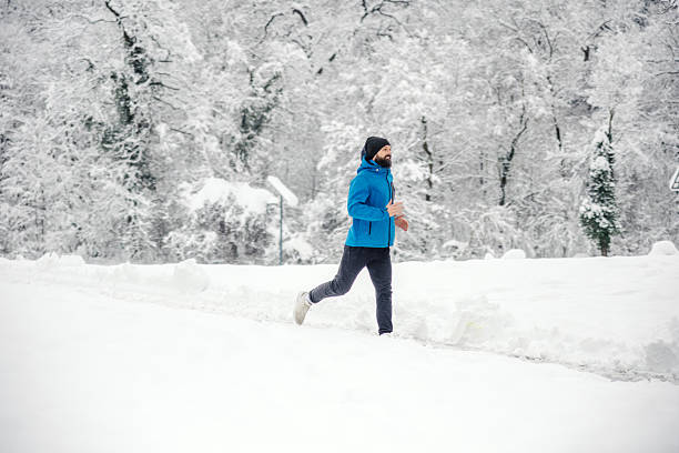 istock Man running on snowy path in winter forest 2254926654