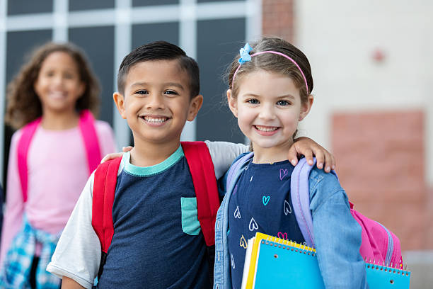 istock Happy, diverse elementary school children with backpacks and notebooks ready for school. 2254930956