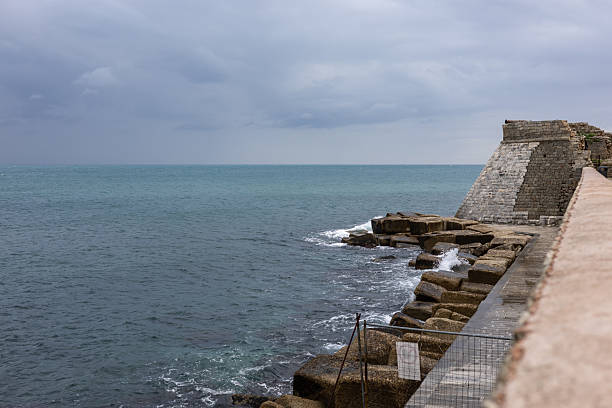 istock ancient stone bastion and defensive sea wall overlooking the turquoise ocean under a dramatic cloudy sky, historic coastal fortification and rocky shoreline 2254936480