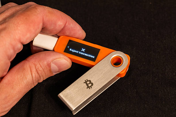 istock Male hand holding hardware wallet with reject transaction option on its screen 2254936513