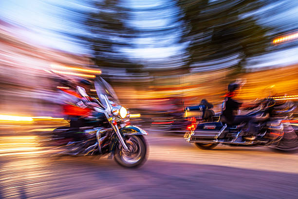 Motorcycles of different styles are gathered at a rally, featuring unique designs and detailing. Riders enjoy the atmosphere while showcasing their prized bikes under clear skies.