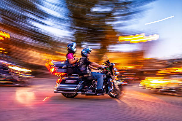 Motorcyclists speed through the street on custom bikes, capturing dynamic motion with panning shot and a nostalgic, energetic feel.