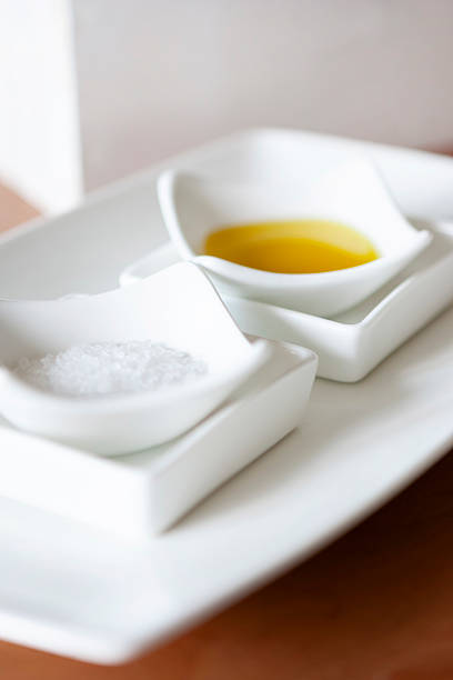 White ceramic dishes with olive oil and sea salt for bread dipping or seasoning service at restaurant
