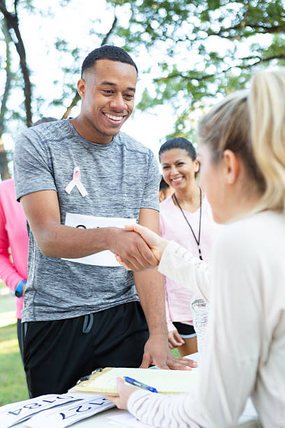 istock Man shakes hands at event table after race, celebrating participation and awareness. 2254943271
