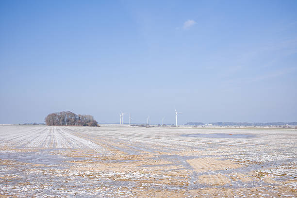 Landscape with new fallen snow. Wind turbine close-up on pause. Shadow of wind mill