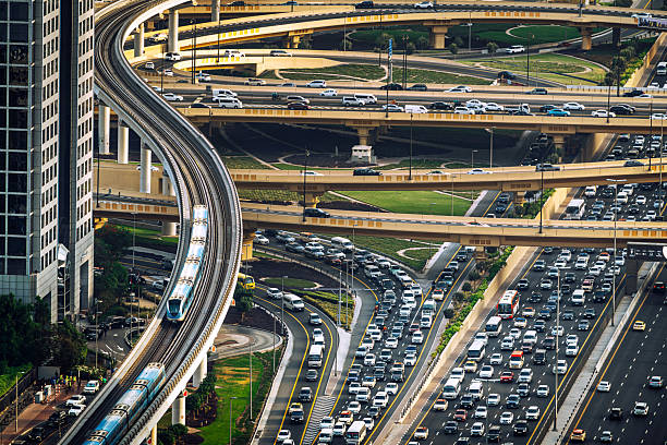 A detailed aerial view of a busy highway interchange in Dubai, UAE, showcasing overpasses, metro tracks, and high-density vehicular traffic, reflecting urban infrastructure, transportation, and daily commutes.Sheikh Zayed Road, Dubai, UAE