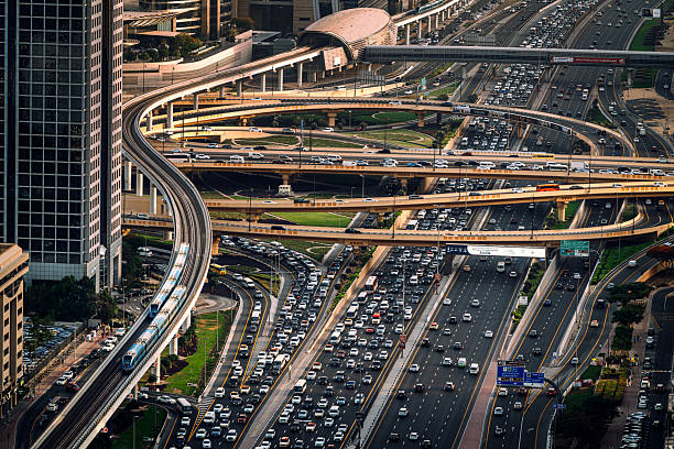 A detailed aerial view of a busy highway interchange in Dubai, UAE, showcasing overpasses, metro tracks, and high-density vehicular traffic, reflecting urban infrastructure, transportation, and daily commutes.Sheikh Zayed Road, Dubai, UAE