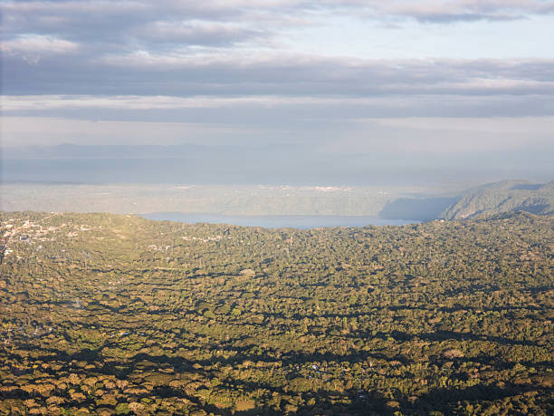 istock Lush green landscape with distant water view in afternoon light 2254953431