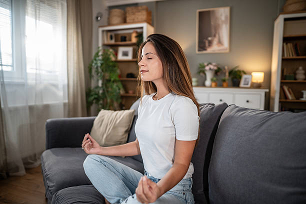 istock Woman meditating on couch for stress relief and mindfulness 2254953901