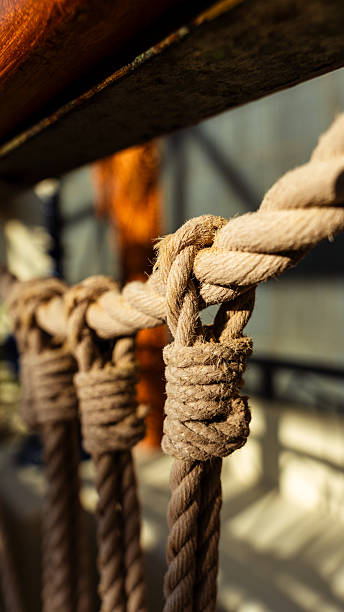 Ropes tied with strong knots securing ship's rigging on a wooden deck