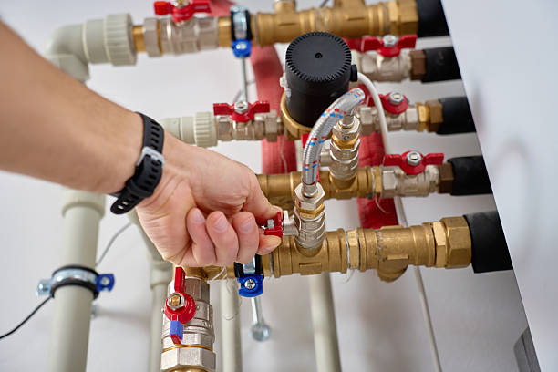 istock Technician adjusting valve on heat pump piping system close up 2254956944