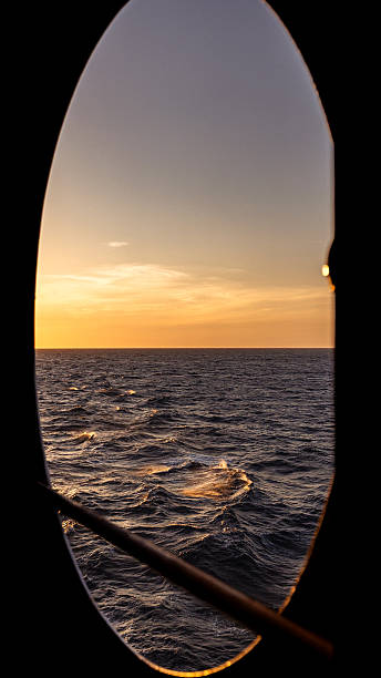 istock Porthole overlooking ocean at golden hour sunset 2254956993