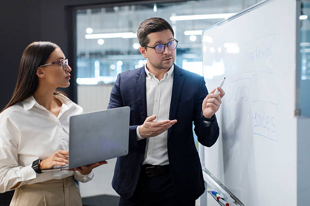 istock Business colleagues planning and developing new project, discussing successful business strategy plan in front of whiteboard 2254958471