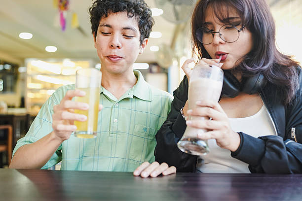 Young couple enjoying drinks together at cafe relaxing