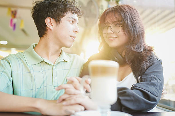 istock Young couple holding hands at cafe on a date 2254958975