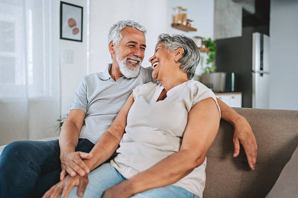 istock Happy Smiling Senior Couple Laughing Together on Sofa 2254960475