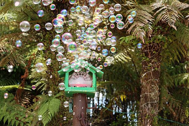 Shimmering spheres float upward among lush foliage outdoor playful floating