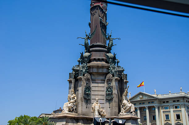 Barcelona, Spain - May 12, 2023: Monument a Colom framed by palm trees and empty road leading towards it