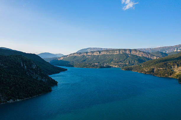 istock Wide blue lake with forested hills and clear sky 2254963287