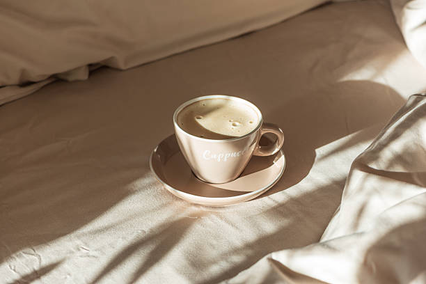 istock Cappuccino Cup on Cozy Bed with Sunlight and Beige Bedding 2254964928