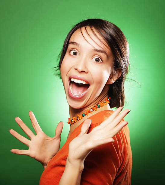 Beautiful young surprised woman over green background